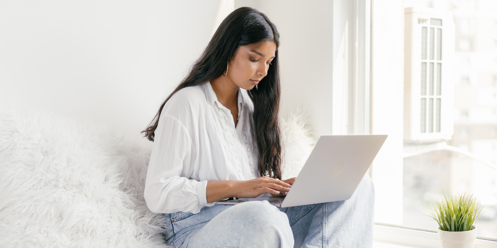 College student looking at laptop on couch