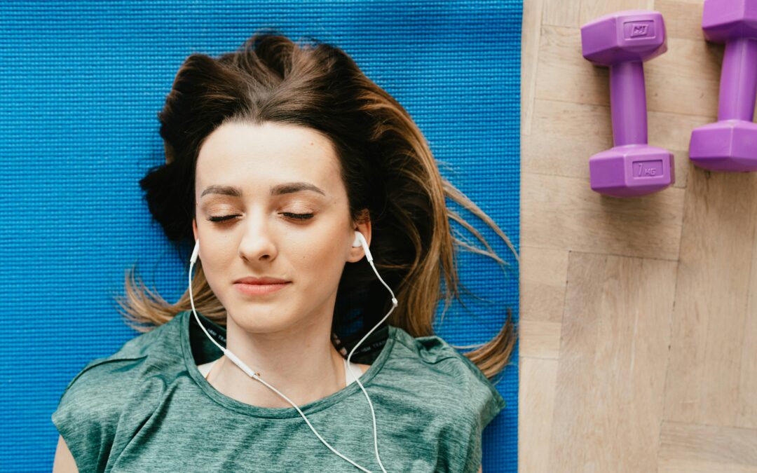 woman on yoga mat listening to music